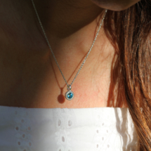 Delicate sterling silver pendant with small, polished dots surrounding a Blue Topas gem.