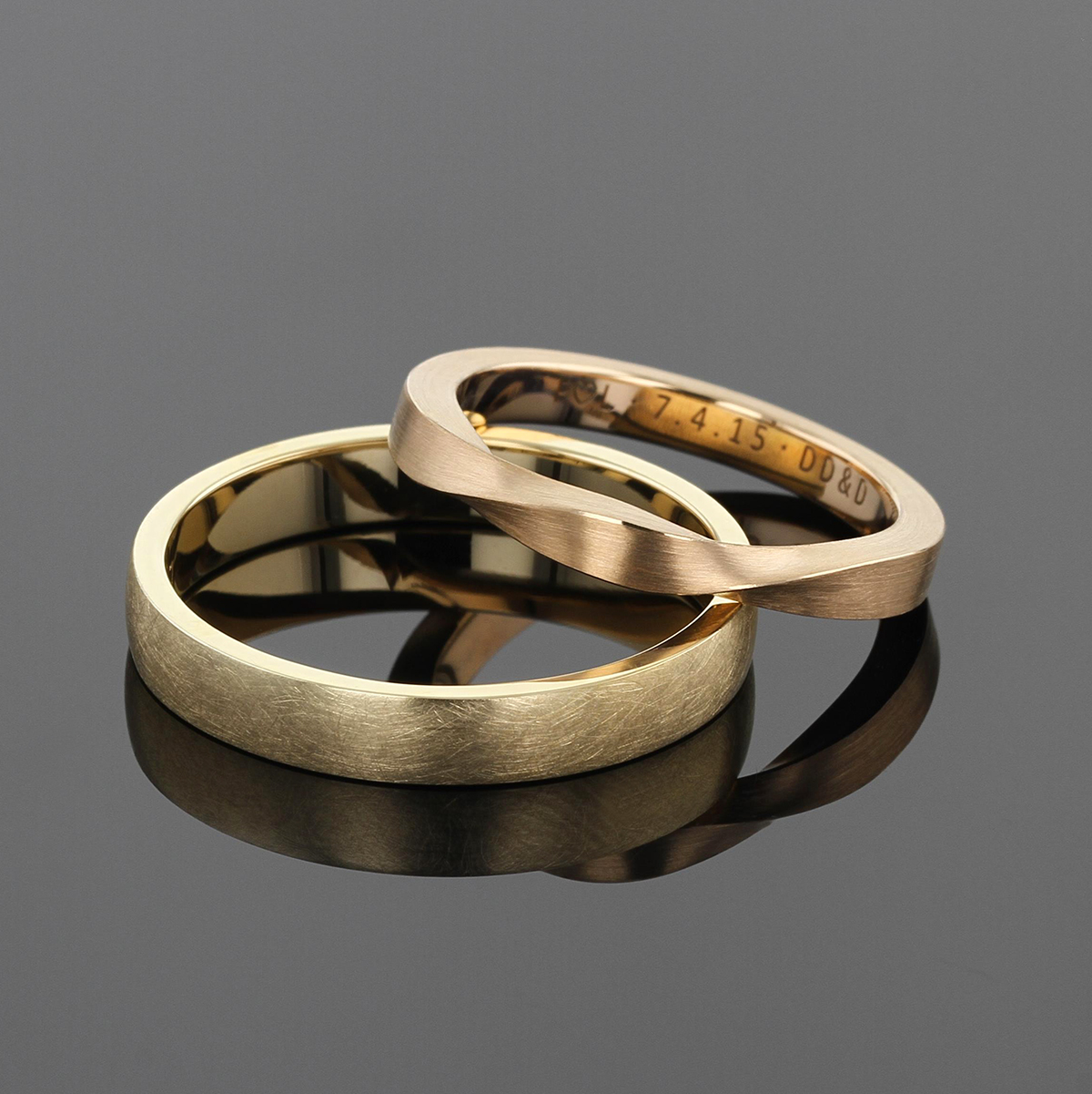 Wedding bands for him and her. A simple band in matted yellow gold for him and a rose gold band with a twisted top for her.