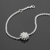 Fine anchor bracelet in silver with a dandelion flower at its center.