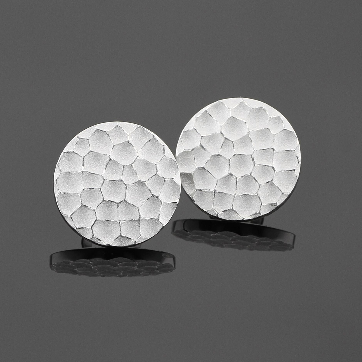 Round earrings in sterling silver with a rock texture