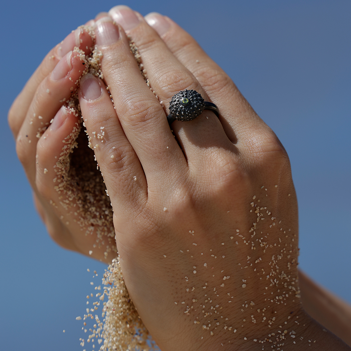 Tiny sea urchin ring in black silver with a Peridot stone