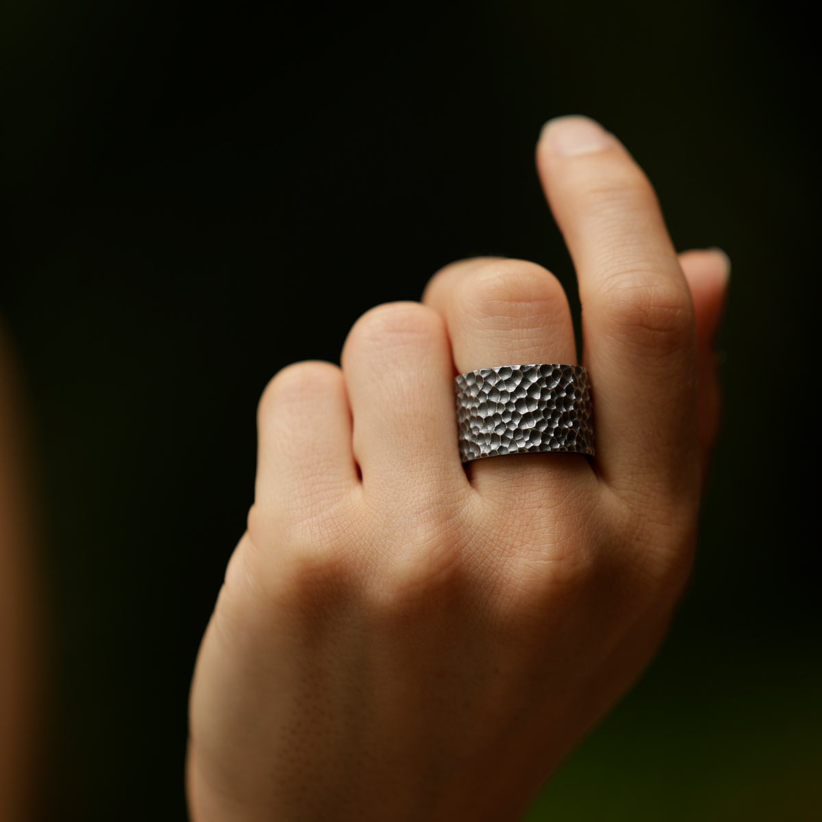 Wide ring in oxidised silver with a lava rock texture