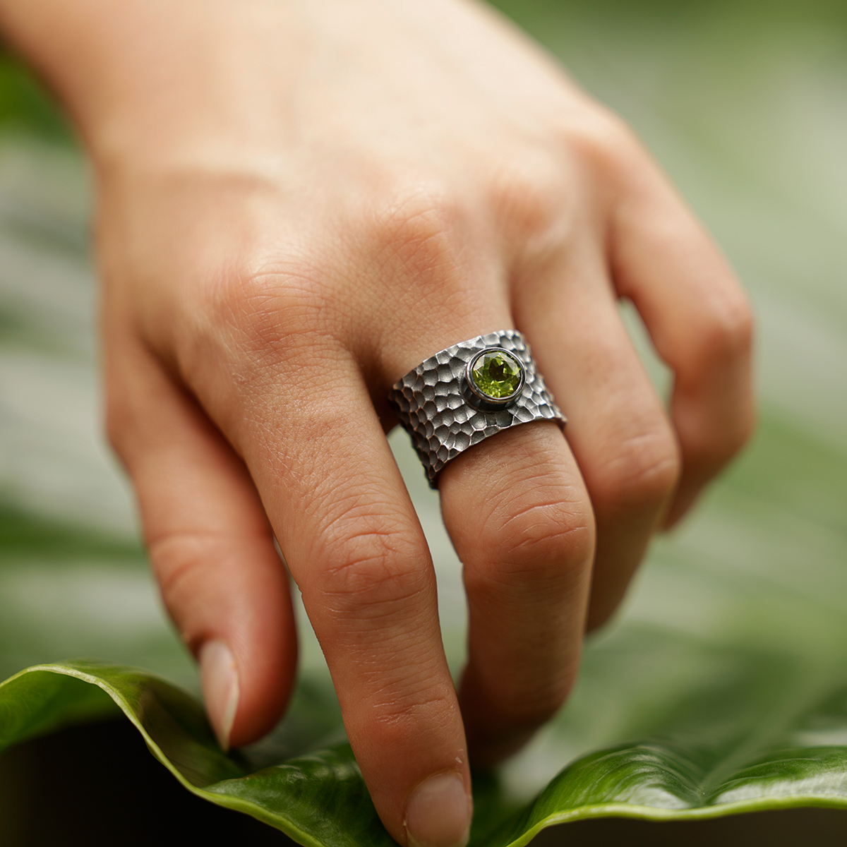 Wide ring in black silver with a rock texture and Peridot gemstone