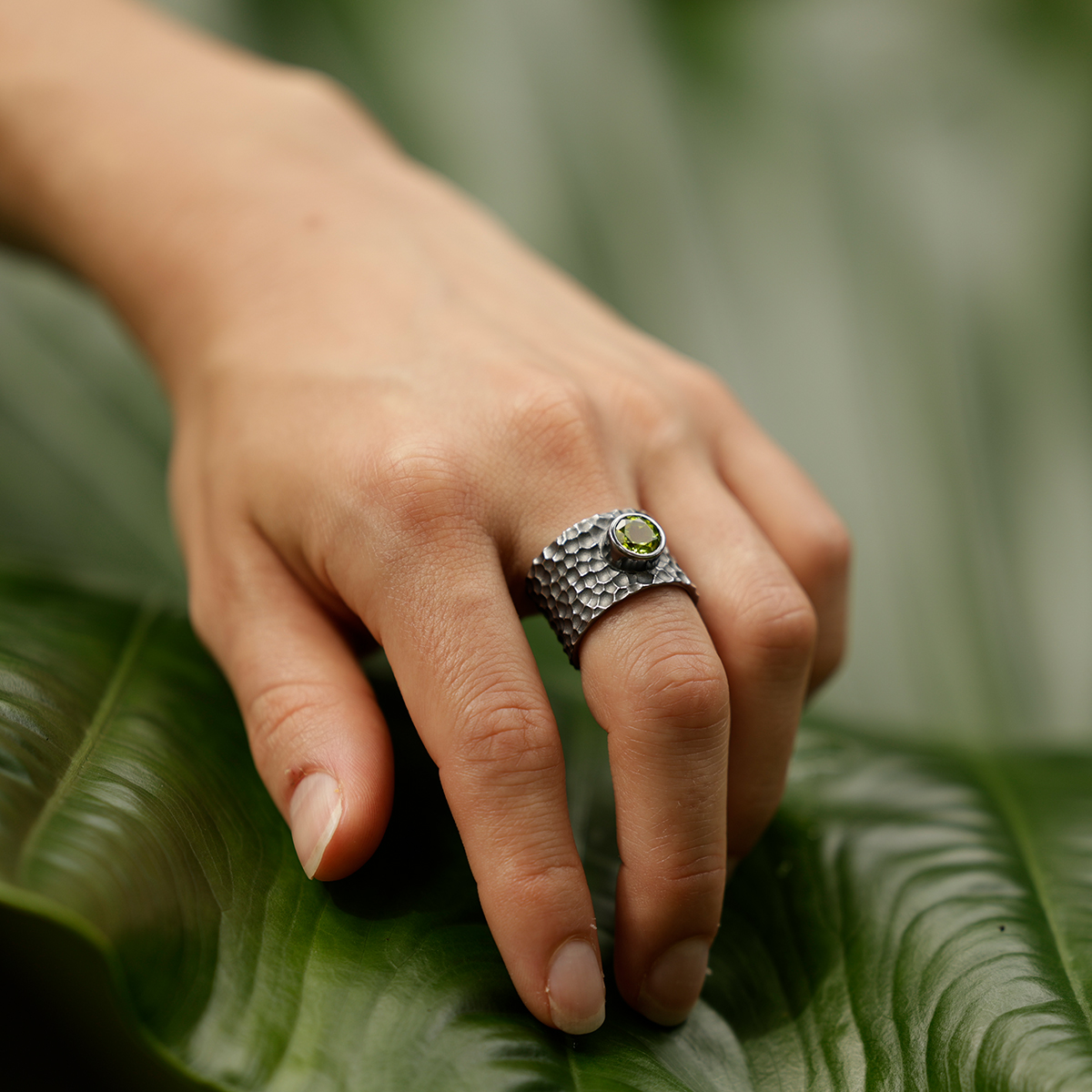 Wide ring in black silver with a rock texture and Peridot gemstone