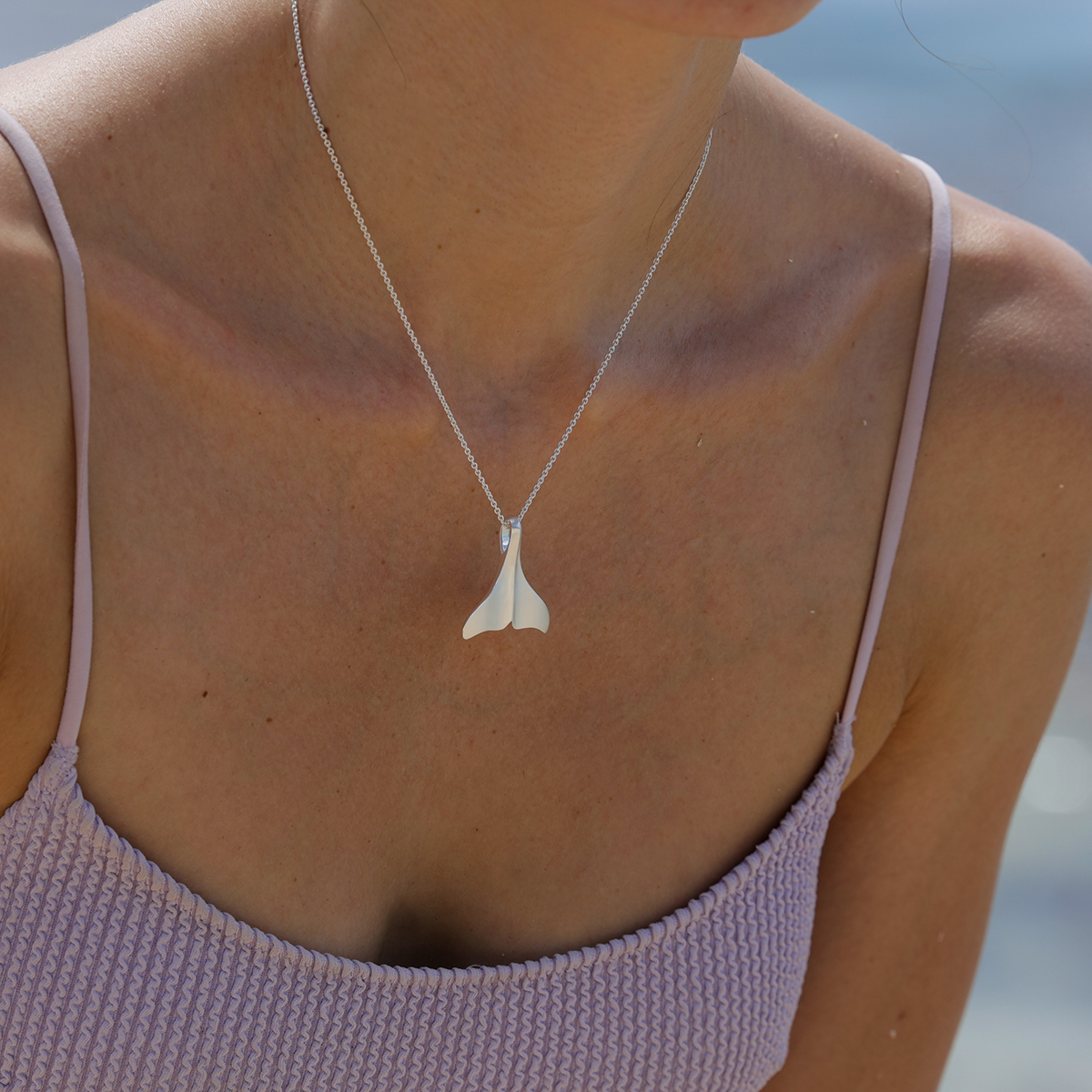 Whale fin pendant in a matted silver