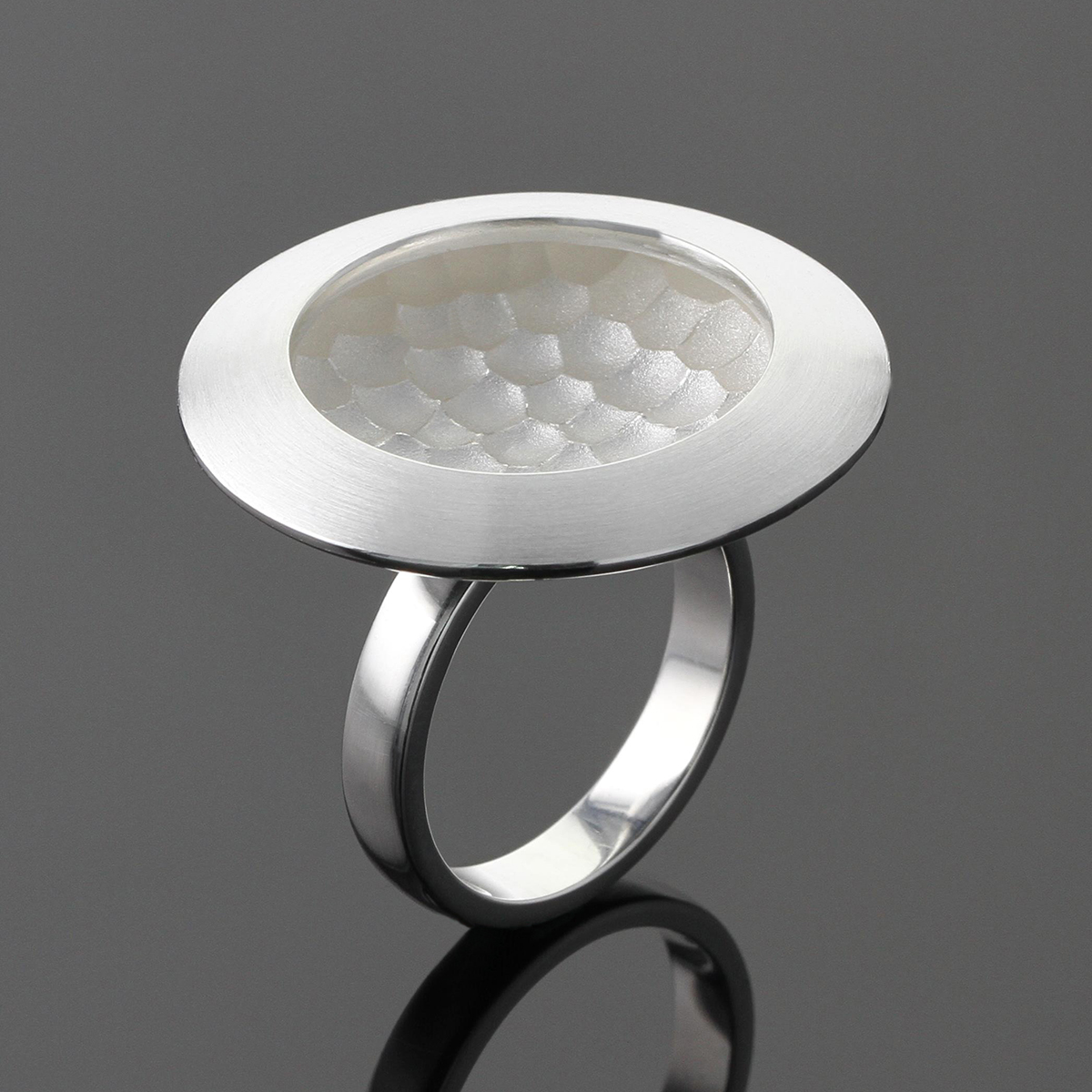 Silver ring with a rock textured concave surface