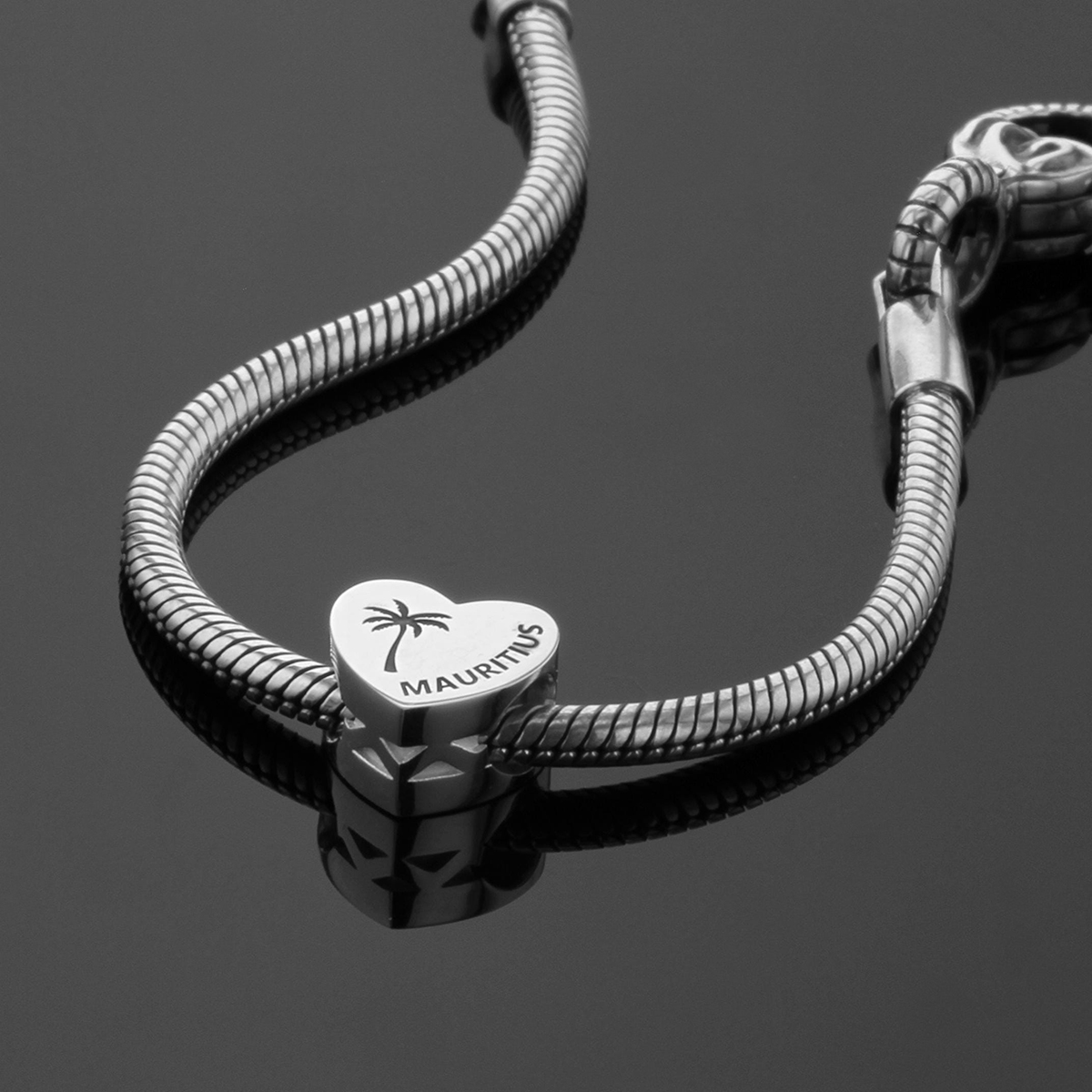 Heart shaped bead in polished silver with a Mauritius engraving