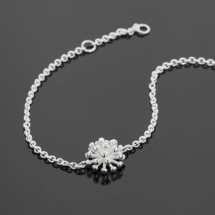 Fine anchor bracelet in silver with a dandelion flower at its center.