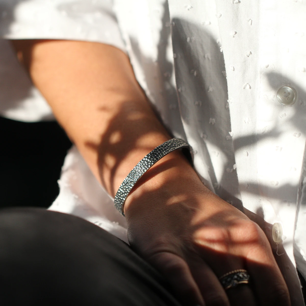 Oval shaped, open bangle in oxidised sterling silver with our unique lava rock texture.