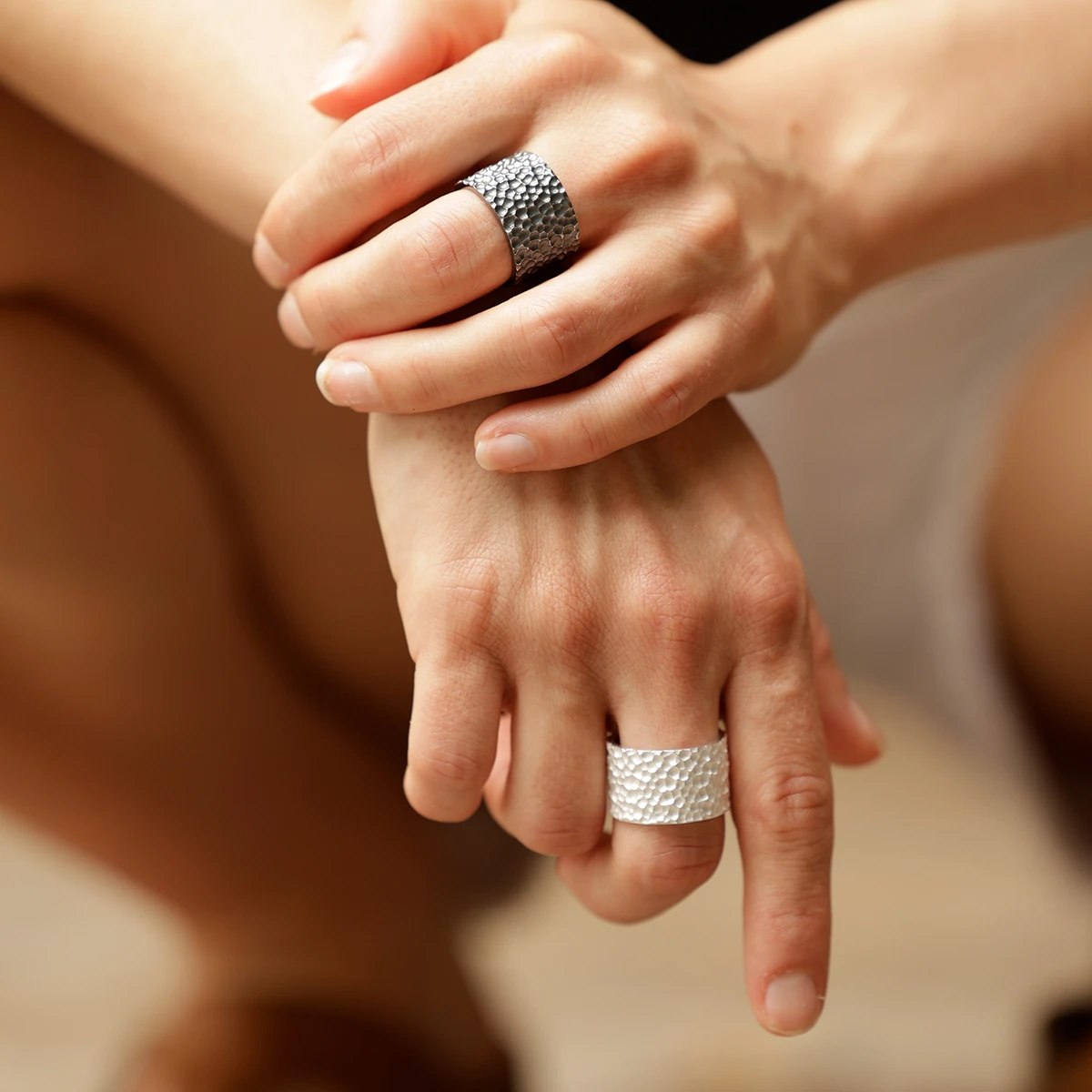 Wide rings in oxidised and white silver with a lava rock texture