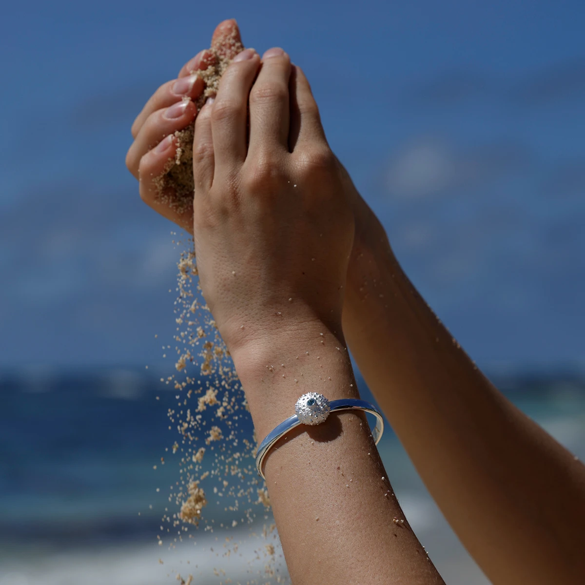 Polished silver bangle with a sea urchin head and a Blue Topas stone